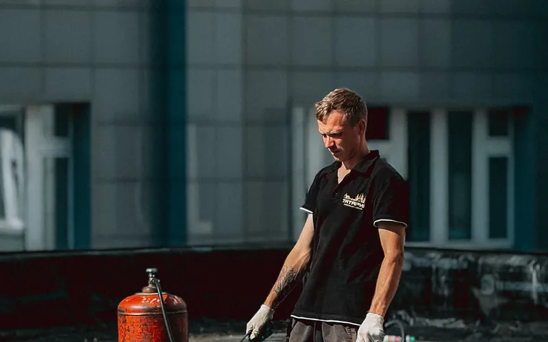 Pracownik przy wykonywaniu pokrycia dachowego